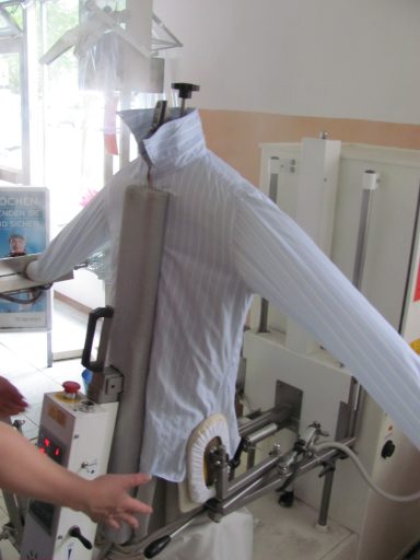 Oberhemd wird mit einer Dampfbügeleisenmaschine gebügelt.